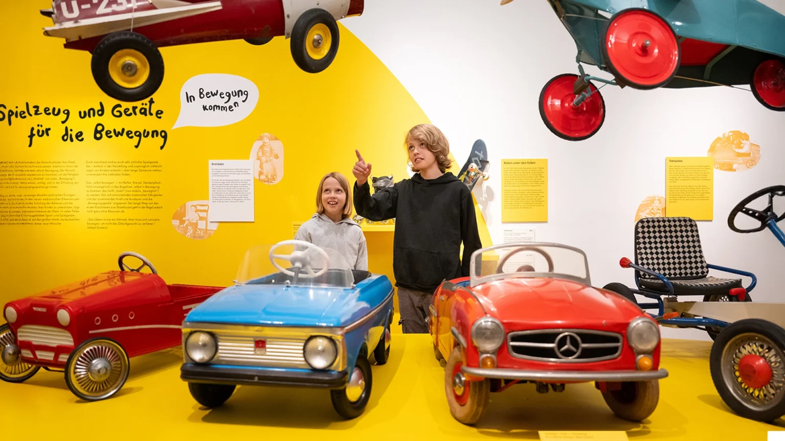 Raumansicht der Ausstellung ‚Kutsche, Dreirad, Bobbycar. Kindermobilität aus zwei Jahrhunderten‘ im Schloss Fasanerie, Studio Neue Museen